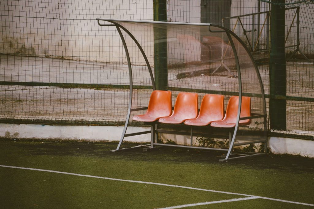 una hilera de sillas naranjas sobre una cancha de tenis